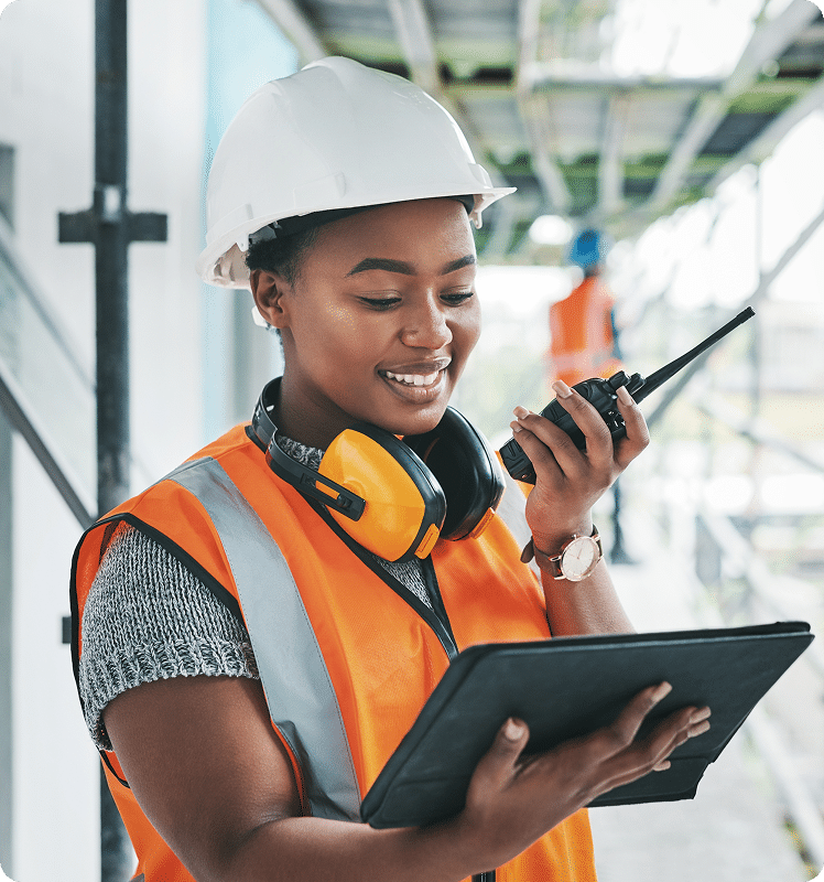Construction worker on radio looking at tablet